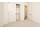Bedroom with a closet, neutral carpet, off white walls, and open door leading to another room at 1903 E Empeltre Rd, San Tan Valley, AZ 85140
