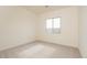 Bright bedroom featuring neutral carpet, white walls, and a large window providing natural light at 1903 E Empeltre Rd, San Tan Valley, AZ 85140