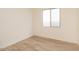 Bright bedroom with wood-look tile flooring, neutral walls, and ample natural light from window at 1903 E Empeltre Rd, San Tan Valley, AZ 85140