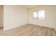 Bright bedroom with neutral walls, wood-look tile flooring, and a window offering natural light at 1903 E Empeltre Rd, San Tan Valley, AZ 85140