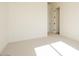Bright bedroom with neutral carpet, white walls, and a doorway to an adjacent space at 1903 E Empeltre Rd, San Tan Valley, AZ 85140