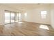 Bright living room with wood floors and sliding glass doors that lead to the backyard at 1903 E Empeltre Rd, San Tan Valley, AZ 85140