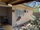 Exterior view of the side of the home with a window air conditioning unit and a boarded-up cat door at 2030 N 21St Pl, Phoenix, AZ 85006