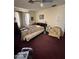 A bedroom with red carpet, a ceiling fan, and natural light from the windows with blinds at 2102 W Hazelwood St, Phoenix, AZ 85015