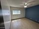 Cozy bedroom with tile flooring, natural light, and a ceiling fan for added comfort at 220 S Old Litchfield Rd # 104, Litchfield Park, AZ 85340