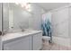 Bathroom with large vanity, decorative shower curtain, and white marble-esque tile at 2230 N Los Alamos --, Mesa, AZ 85213