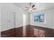 Spacious bedroom with hardwood floors, ceiling fan, and a bright window offering ample natural light at 2230 N Los Alamos --, Mesa, AZ 85213