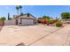 Spacious driveway leading to a well-maintained home with vibrant landscaping and desert-friendly yard at 2230 N Los Alamos --, Mesa, AZ 85213