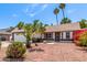 Inviting home exterior with neat landscaping, including palm trees, bougainvillea, and decorative stone at 2230 N Los Alamos --, Mesa, AZ 85213