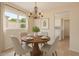 Charming dining area with a round wood table, chandelier lighting, and a view from the bright window at 2234 E Lawrence Rd, Phoenix, AZ 85016