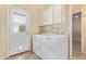 Functional laundry room with white cabinets, modern washer and dryer, and exterior access at 2234 E Lawrence Rd, Phoenix, AZ 85016