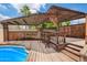 Outdoor entertaining space featuring a spacious wooden pergola with a built-in bar and view of the pool at 2234 E Lawrence Rd, Phoenix, AZ 85016