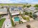 Aerial view featuring a backyard pool, lush landscaping, solar panels, and expansive yard space with green fields beyond at 22737 N Sunset Dr, Maricopa, AZ 85139