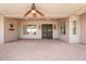 A large, covered back patio featuring a ceiling fan and access to both the main house and backyard at 22737 N Sunset Dr, Maricopa, AZ 85139