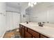 Bright bathroom with double sinks, a large mirror, and neutral tile floors at 22737 N Sunset Dr, Maricopa, AZ 85139
