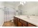 Bathroom featuring wood cabinets, double sinks, and a large mirror over the vanity at 22737 N Sunset Dr, Maricopa, AZ 85139