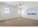 Bright bedroom featuring a ceiling fan, neutral carpet, and many windows dressed with white wood blinds at 22737 N Sunset Dr, Maricopa, AZ 85139