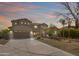 Charming two-story home at dusk featuring manicured landscaping, a two-car garage and elegant curb appeal at 22737 N Sunset Dr, Maricopa, AZ 85139