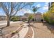 Charming home exterior with desert landscaping, brick walkway, mature trees, and a well-manicured front yard at 22737 N Sunset Dr, Maricopa, AZ 85139