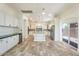 Kitchen with island, white cabinets, stainless appliances, tile floors and sliding glass door at 22737 N Sunset Dr, Maricopa, AZ 85139