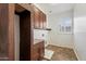 Well lit laundry room with tile floors, wood cabinets, granite countertops, and a utility sink at 22737 N Sunset Dr, Maricopa, AZ 85139