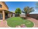 Backyard featuring a putting green, a covered patio, rocks and a landscaped design at 24813 W Rosita Ave, Buckeye, AZ 85326