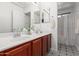Double vanity bathroom with tiled floors, mirrors, and lots of natural light at 24813 W Rosita Ave, Buckeye, AZ 85326