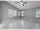 Bright bedroom with tile flooring, multiple windows, and a ceiling fan at 24813 W Rosita Ave, Buckeye, AZ 85326