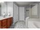 Bathroom featuring a soaking tub, glass shower, and granite-topped vanity at 24813 W Rosita Ave, Buckeye, AZ 85326