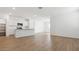 Bright, open-concept living space featuring wood-look flooring and a modern kitchen with stainless appliances at 25165 N 183Rd Dr, Wittmann, AZ 85361