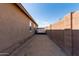Side yard features desert landscaping, block wall fencing, and space to store a small trailer at 25447 W Heathermoor Dr, Buckeye, AZ 85326