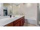 Bathroom featuring a tub and shower combination, a spacious vanity, and a large mirror at 25447 W Heathermoor Dr, Buckeye, AZ 85326