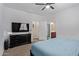 Bedroom with a television, dresser and access to the bathroom and closet at 25447 W Heathermoor Dr, Buckeye, AZ 85326