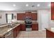 Traditional kitchen featuring granite countertops, stainless steel appliances, and tiled flooring at 25447 W Heathermoor Dr, Buckeye, AZ 85326