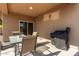 Outdoor patio with a table, chairs, grill, and a covered ceiling, ideal for outdoor relaxation and dining at 25447 W Heathermoor Dr, Buckeye, AZ 85326