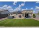 Backyard featuring artificial grass, gravel landscaping, and a covered patio with a jacuzzi at 25930 N 165Th Ln, Surprise, AZ 85387