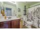 Bathroom with a green wall and a shower with a curtain showing a desert scene at 25930 N 165Th Ln, Surprise, AZ 85387