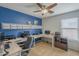Bright office with a blue accent wall, ceiling fan, built in shelving, and carpet flooring at 25930 N 165Th Ln, Surprise, AZ 85387