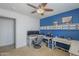 Bright office with a blue accent wall, ceiling fan, built in shelving, and carpet flooring at 25930 N 165Th Ln, Surprise, AZ 85387