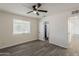 This airy bedroom features wood-look floors, a ceiling fan, a window with blinds and a door to the bathroom at 3202 W Glenrosa Ave, Phoenix, AZ 85017