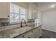Kitchen sink with granite countertops, white cabinets and plenty of natural light at 3202 W Glenrosa Ave, Phoenix, AZ 85017