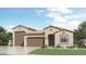 Inviting single-story home showcasing a spacious three-car garage and beautiful desert landscaping at 32452 N Cherry St, San Tan Valley, AZ 85143