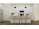Contemporary kitchen featuring white cabinets, modern appliances, and a functional island with stylish bar stools at 32452 N Cherry St, San Tan Valley, AZ 85143