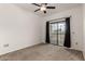 Carpeted bedroom with ceiling fan and sliding glass doors leading to a private balcony at 3434 E Baseline Rd # 216, Phoenix, AZ 85042