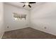 This carpeted bedroom includes a ceiling fan and a window for plenty of natural light at 3434 E Baseline Rd # 216, Phoenix, AZ 85042