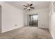 Bedroom with neutral carpet, a ceiling fan, and a sliding glass door to the balcony at 3434 E Baseline Rd # 216, Phoenix, AZ 85042