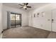 Bedroom with neutral carpet, a ceiling fan, and a sliding glass door to the balcony at 3434 E Baseline Rd # 216, Phoenix, AZ 85042
