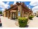 Exterior community building with landscaped sidewalk and pergola with reserved parking spot at 3434 E Baseline Rd # 216, Phoenix, AZ 85042