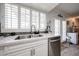 Close up of kitchen sink area with white cabinetry, stainless steel appliances, and bright window shutters at 3608 W Villa Rita Dr, Glendale, AZ 85308