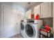 Efficient laundry room featuring modern washer and dryer units with ample storage space at 3608 W Villa Rita Dr, Glendale, AZ 85308